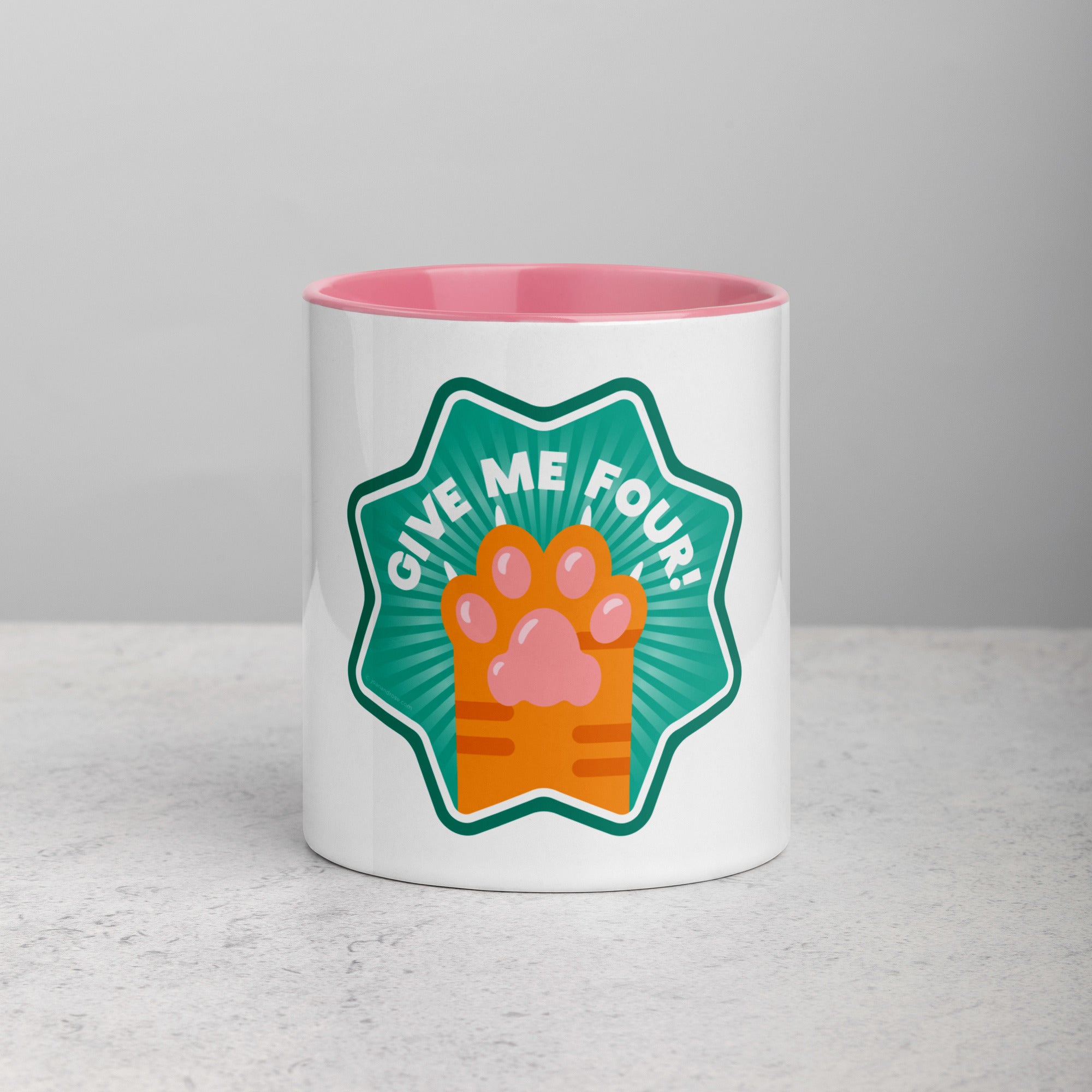 front facing image of a white mug with pink interior and handle. Mug has image of a ginger cats paw on an aqua 8 sided star with the text 'give me four' 